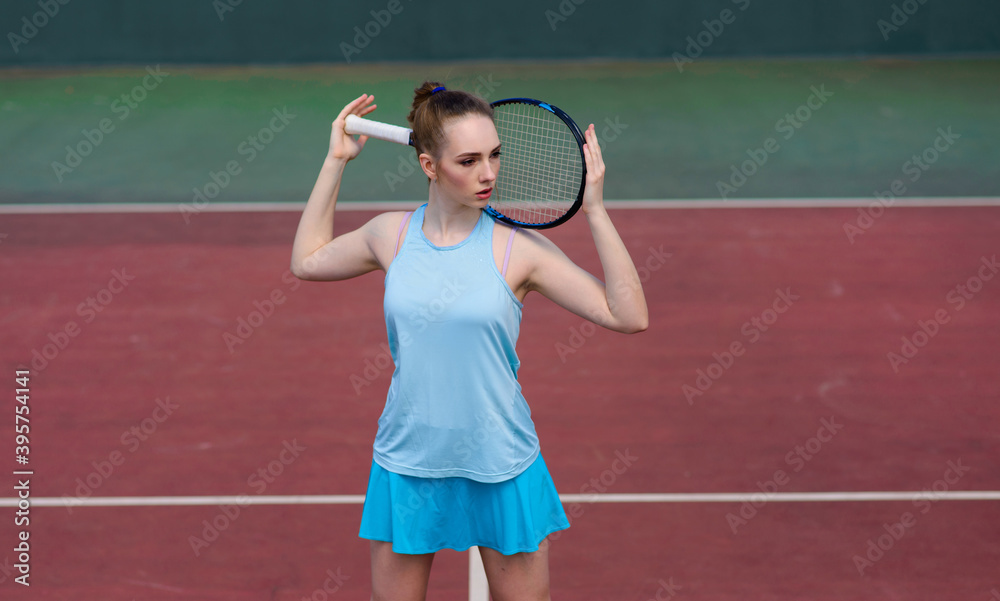Sexy girl tennis player holding tennis racket on the court. Young woman is playing tennis.