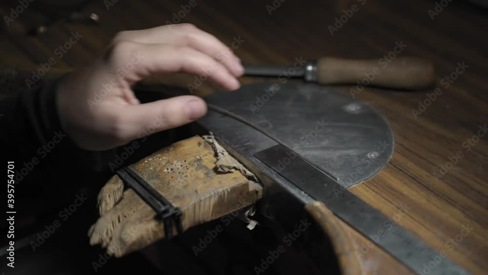 Close up of a woman working with tools in artisan workshop. She is using a tool. Close up of a woman working with tools in artisan workshop. She is using a tool.