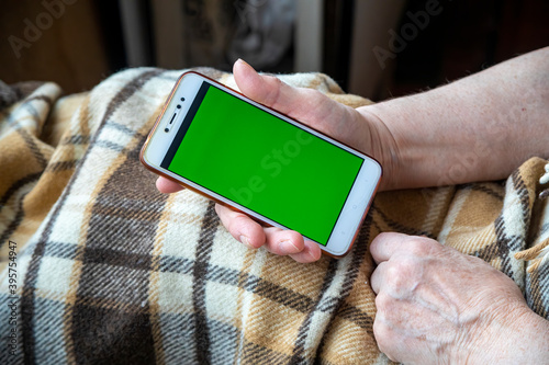 Old woman hands with a mobile phone calling for delivery or emergency services