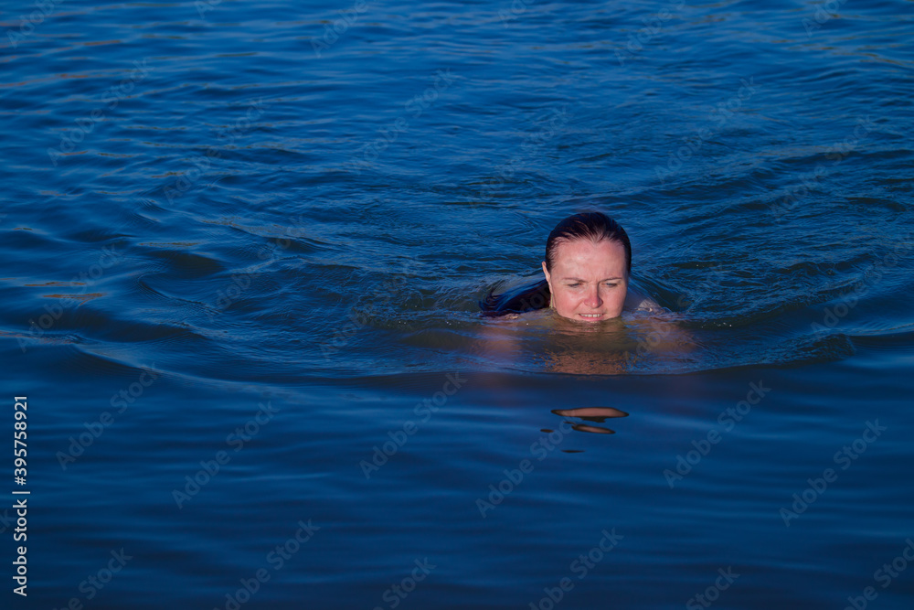 a woman slowly floats on the water