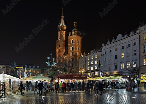 Christmas market on the Main Square of Krakow in front of the St. Mary's Basilica in night, Poland