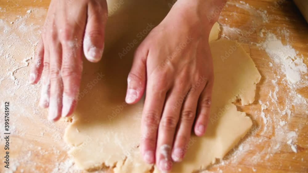 close up overhead shot of hands working flour onto dough baking a pie crust close up overhead shot of hands working flour onto dough baking a pie crust