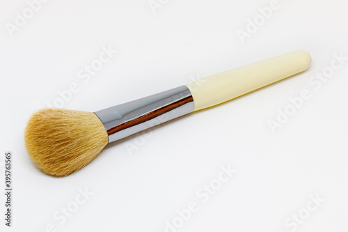 beige makeup brush on white background