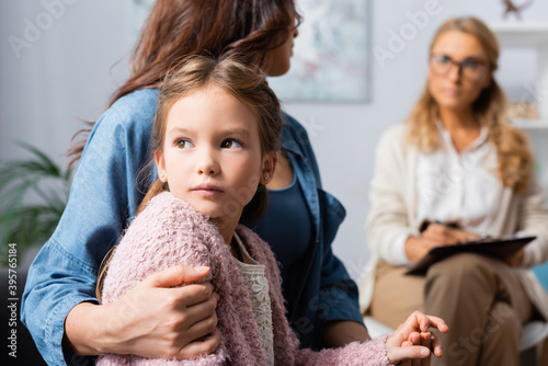 cropped view of mother hugging daughter while visiting psychologist  stock image