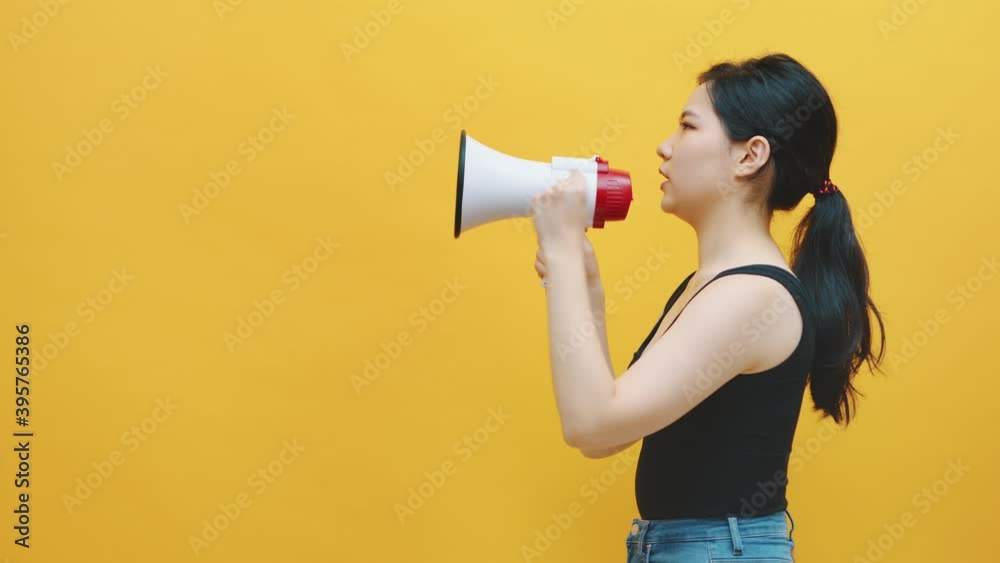 Discount annoncement. Young asian women shouting into the megaphone. Copy space. High quality 4k footage Discount annoncement. Young asian women shouting into the megaphone. Copy space. High quality 4k footage
