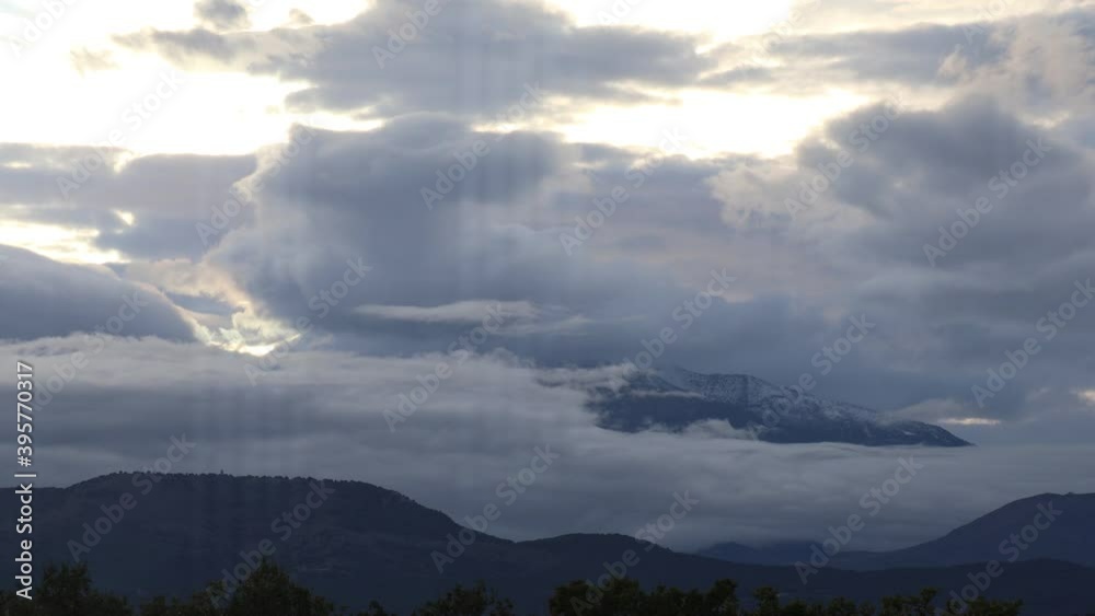 timelapse of clouds dance around snowy mountains