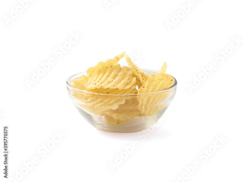 Glass plate full of rippled potato chips with spices and isolated on white
