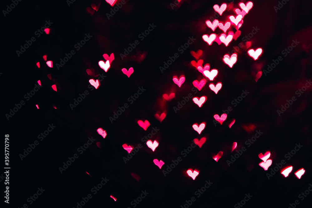Defocused bokeh lights in shape of pink and red hearts.