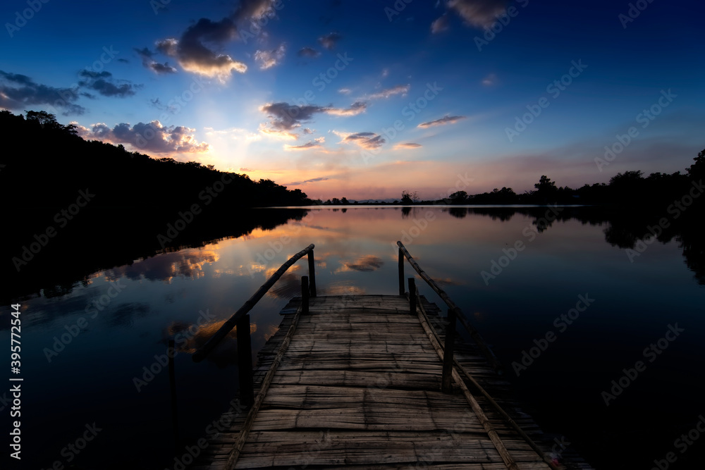 Obraz premium Bamboo bridge By the lake at sunset in thailand