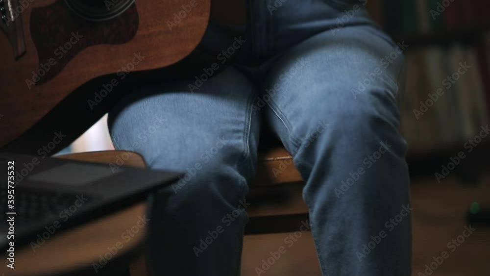 A woman plays a guitar, tapping her foot to the beat. Camera movement from bottom to top. Learning to play musical instruments A woman plays a guitar, tapping her foot to the beat. Camera movement from bottom to top. Learning to play musical instruments