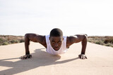 Young black runner doing push-ups.