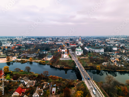 Aerial view of two old churches near river and bridge in small european city