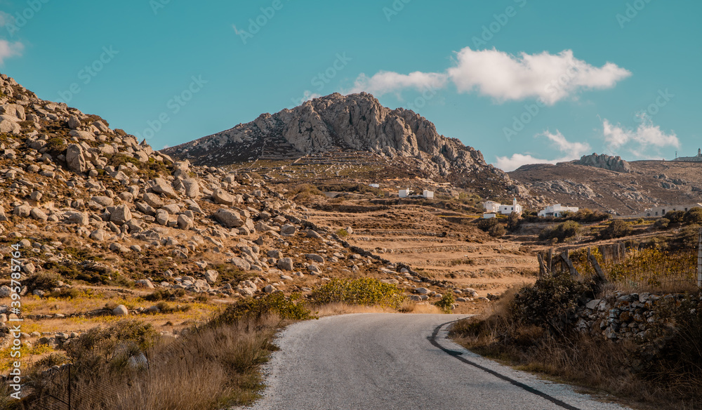 Fototapeta premium A view of road and rocky landscapes in the foothills of Mount Exomvourgo on the island of Tinos, Cyclades, Greece