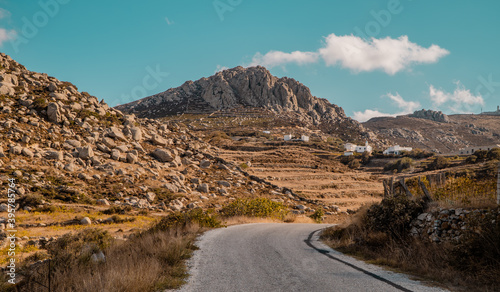 A view of road and rocky landscapes in the foothills of Mount Exomvourgo on the island of Tinos, Cyclades, Greece