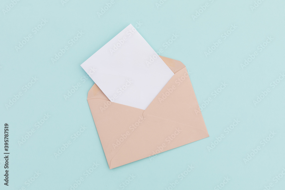 Opened brown envelope with white letter lying over pale blue background Opened brown envelope with white letter lying over pale blue background