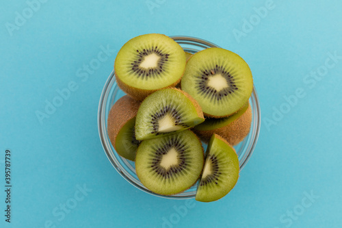 High angle view of bowl of freshly cut kiwi on blue background