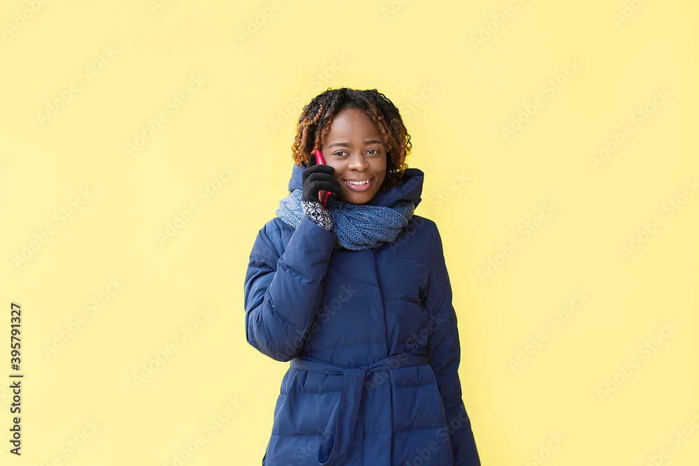 Happy African American walks down the street in winter Happy African American walks down the street in winter