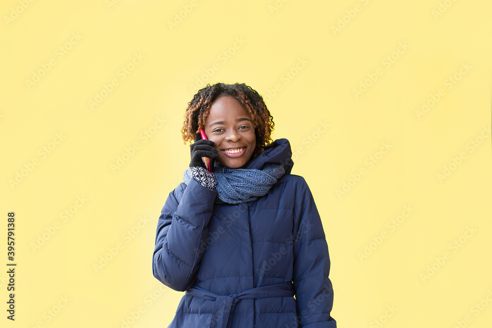 Happy African American walks down the street in winter Happy African American walks down the street in winter