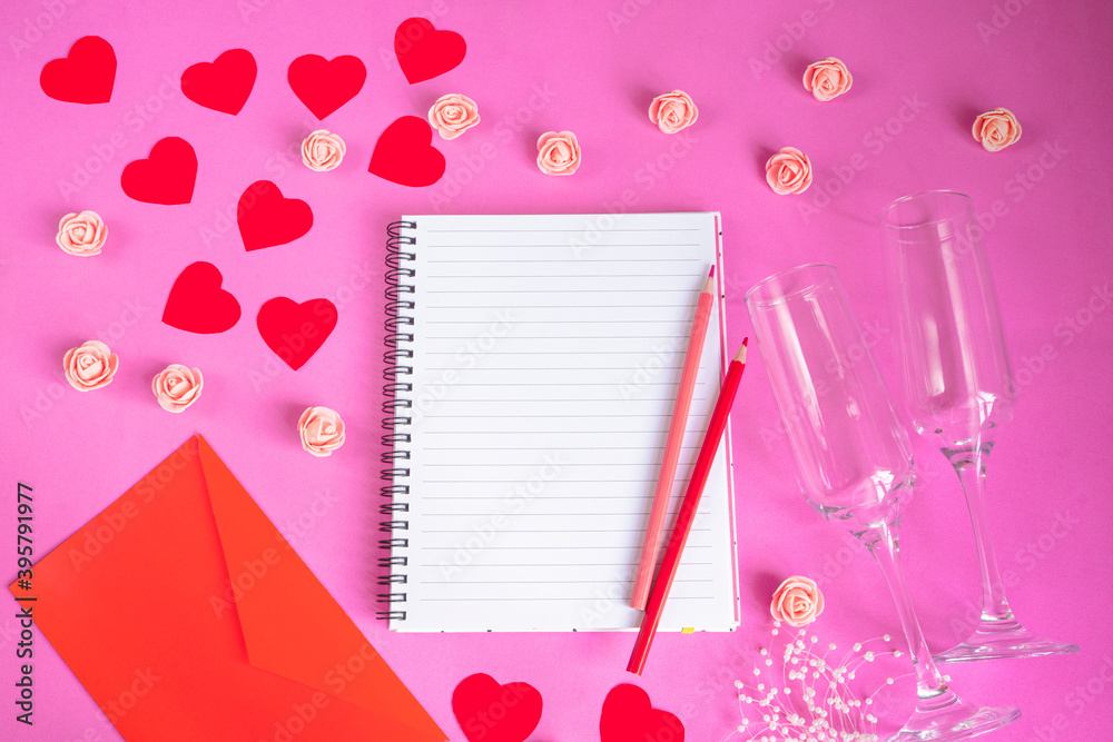 Composition Valentine's Day. Notepad, pencils, glasses, red hearts on a pastel pink background. Concept of a greeting letter for Valentine's Day. Flat lay, top view, copy space.