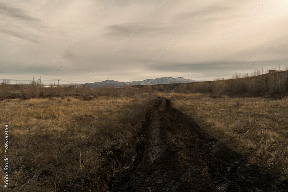 Fototapeta premium Beautiful autumn landscape in the steppe. Country dirt road. Dramatic landscape. Ust-Kamenogorsk outskirts, kazakhstan