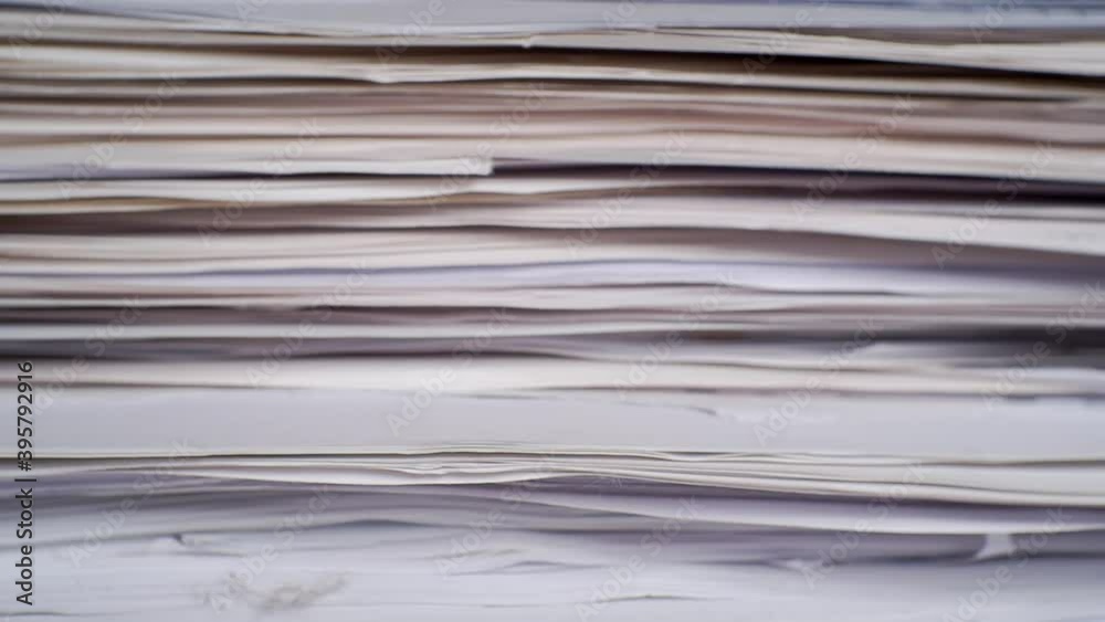 Fingers plucking through a large stack of paper documents.Close-up. Fingers plucking through a large stack of paper documents.Close-up.