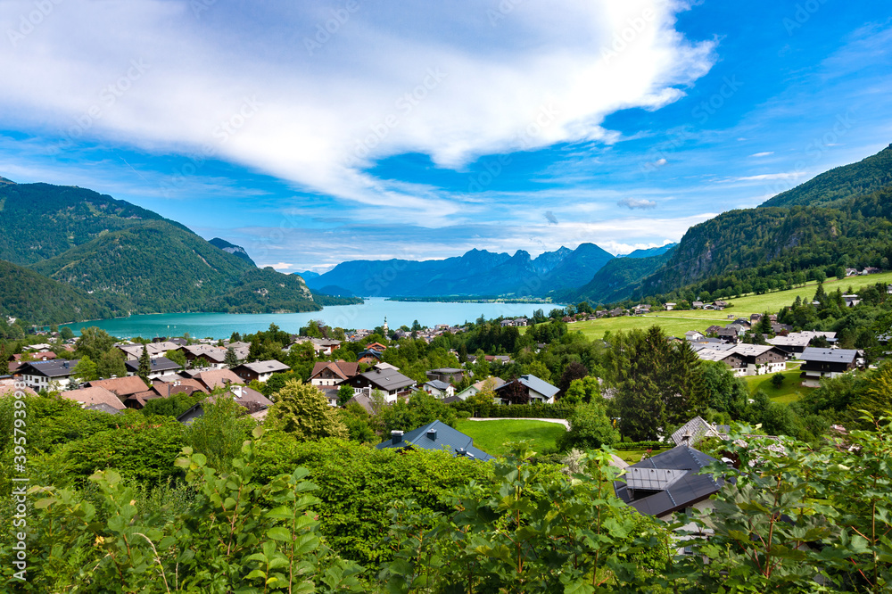 The picturesque valley of the Salzkammergut.Alps.Blue sky with white clouds.Turquoise lake.Mountains in the haze.