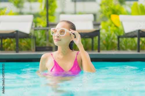 Portrait beautiful young asian woman relax smile around outdoor swimming pool in hotel resort © siraphol