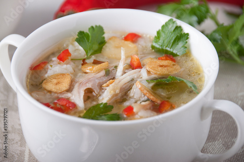 Chicken soup with rice, garlic chips and chili