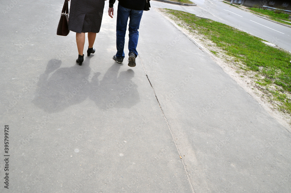A man and a woman are walking along the road. Walk on a summer day. Stroll. A man and a woman are walking along the road. Walk on a summer day. Stroll.