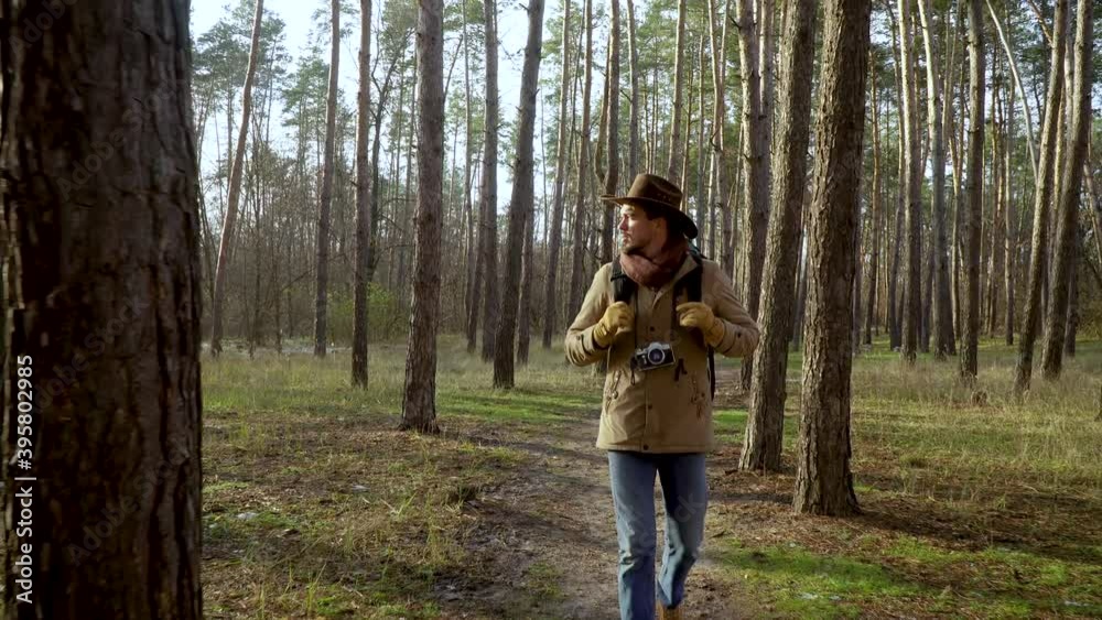 Backpacker with a camera walks along a trail in the forest. Travel concept. 4K Backpacker with a camera walks along a trail in the forest. Travel concept. 4K