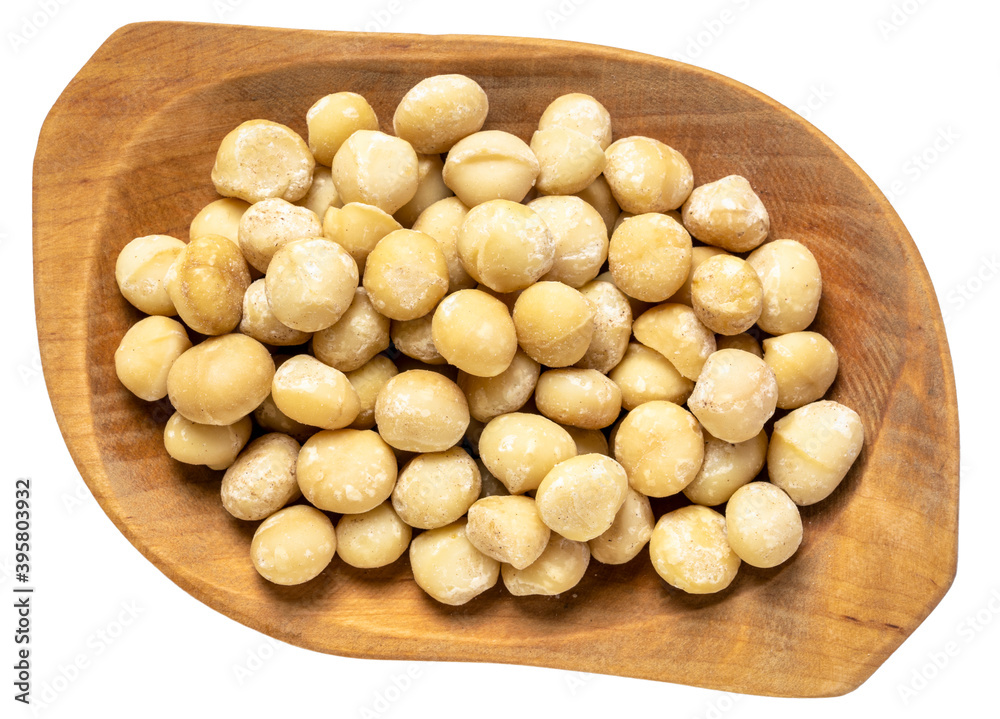 macadamia nuts in a wooden rustic bowl isolated on white macadamia nuts in a wooden rustic bowl isolated on white