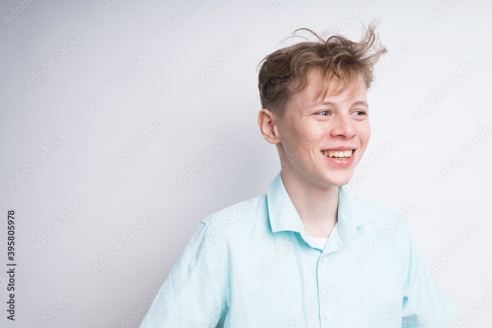 Handsome Caucasian boy with a messy hair smiling on a white background Handsome Caucasian boy with a messy hair smiling on a white background