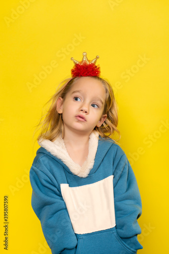 Little girl in toy crown smiling into camera.