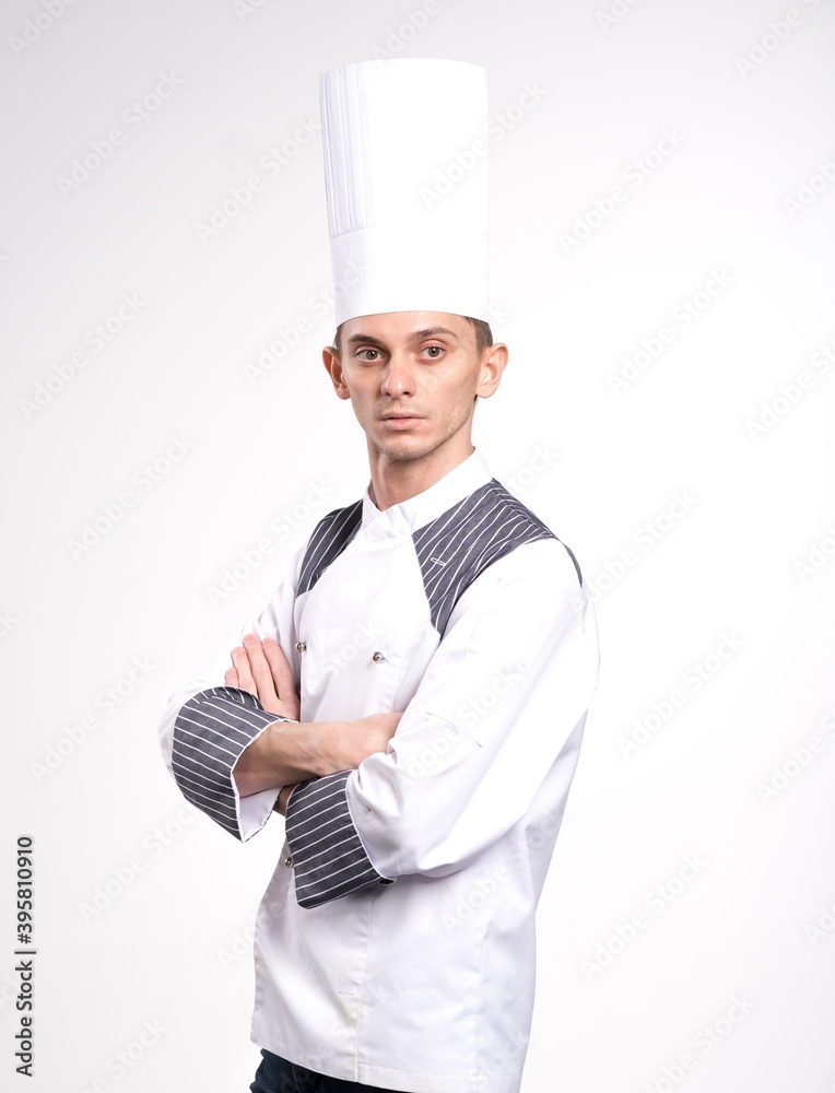 Portrait of positive handsome chef cook in beret and white outfit isolated on white background. Pleased happy young chef posing isolated over white wall background in uniform.