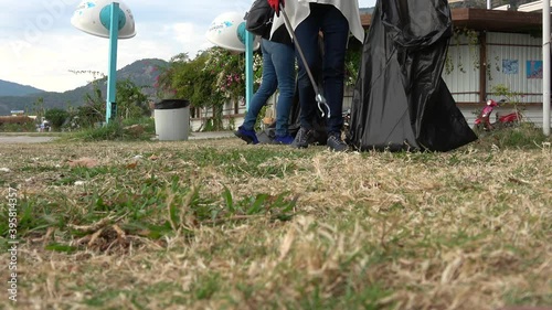 Oludeniz, Fethiye, Turkey - 18th of November 2020: 4K Man collects cigarette ends with a garbage pick-up stick into a black plastic bag
 photo