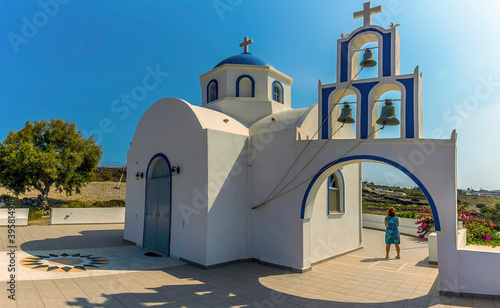 A panorama view of a church and bell tower close to the settlement of Akortiri in Santorini in summertime photo