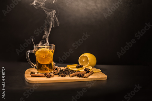 Tea with lemon in a cup on a oard with cinnamon and star anise