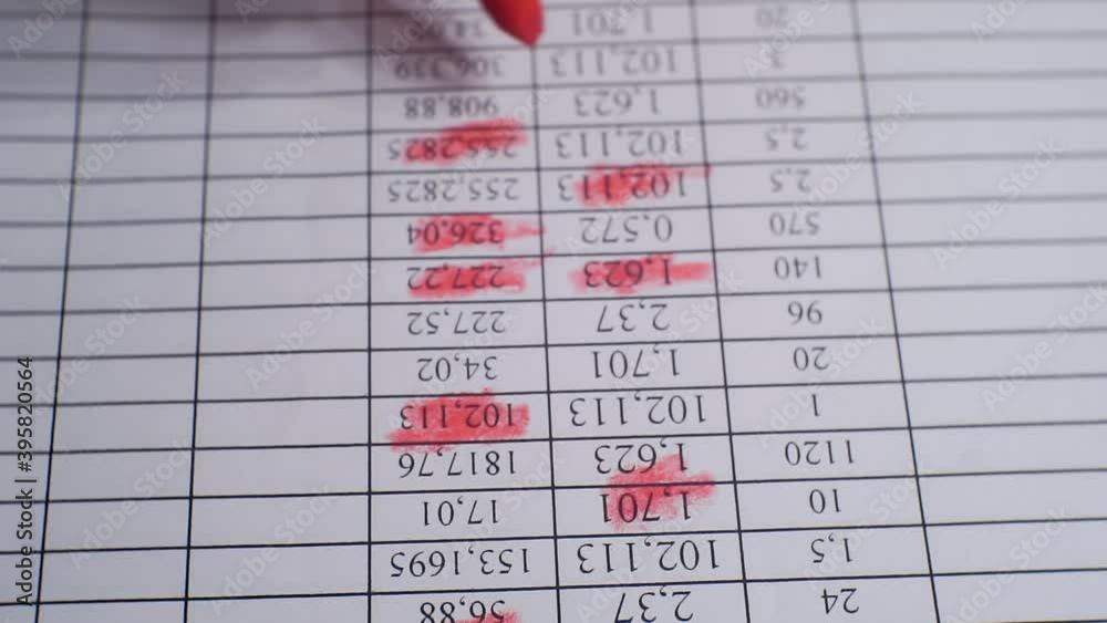 Paperwork.hand makes notes with red marker on a sheet of paper.