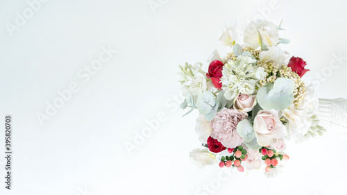 Fototapeta Naklejka Na Ścianę i Meble -  Horizontal banner with a beautiful delicate wedding bouquet made of artificial flowers. Copy or spare bouquet for the bride. Elegant bouquet in pastel shades with copy space for banners, invitations.