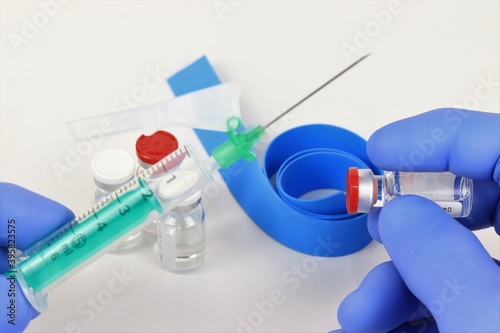 vacuna con manos manipulando viales con jeringa y compresor