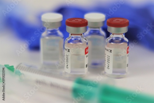 vacuna, viales de medicación con fondo desenfocado de guantes azules y jeringa