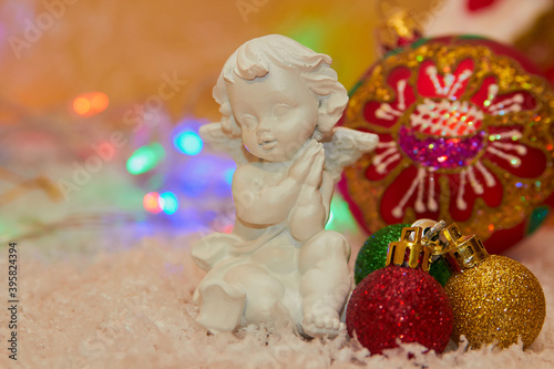 white angel figurine christmas,plaster angel in the snow with Christmas balls decorated