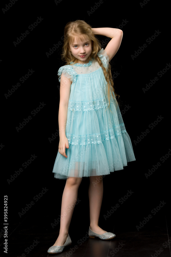 A beautiful little girl straightens her hair on her head. A beautiful little girl straightens her hair on her head.