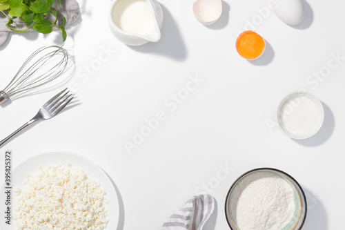 Cottage cheese, eggs, sugar, cream and yougurt on a white background - Flat lay - Space for text