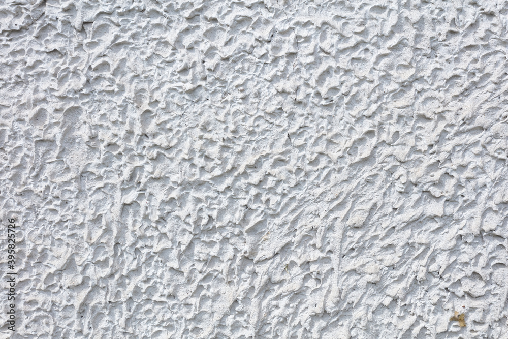 Fragment of a three-dimensional large-relief texture of textured plaster on the exterior of the Foundation of a house outdoor. Fragment of a three-dimensional large-relief texture of textured plaster on the exterior of the Foundation of a house outdoor.