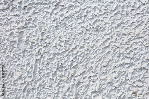 Fragment of a three-dimensional large-relief texture of textured plaster on the exterior of the Foundation of a house outdoor.