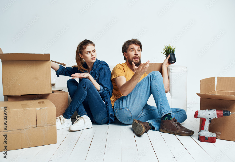 man and woman on the floor with boxes planning moving to apartment man and woman on the floor with boxes planning moving to apartment