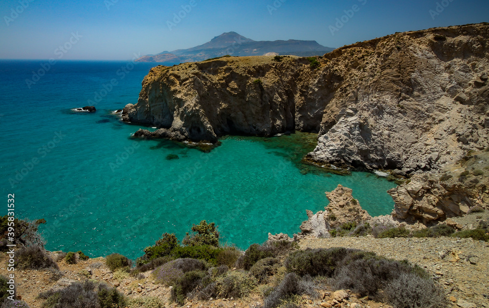 Jagged cliffs plunge into the turquoise waters of the Mediterranean Sea at Tsigrado beach, Milos, Greece Jagged cliffs plunge into the turquoise waters of the Mediterranean Sea at Tsigrado beach, Milos, Greece