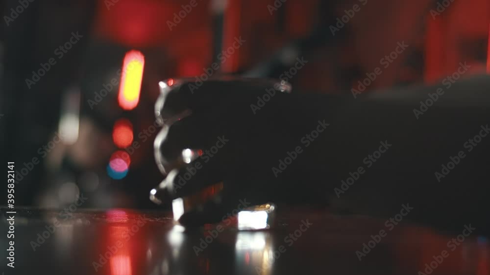 Woman stripper dancing on pole with man putting glass with alcohol on bar counter on foreground