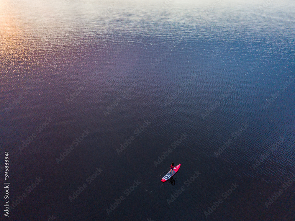 Stand up paddle boarding on a lake during sunset in ontario